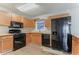 Well-equipped kitchen featuring wooden cabinets, black appliances, and efficient layout for cooking at 42 Breckenridge Dr, Powder Springs, GA 30127