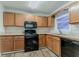 Practical kitchen with wooden cabinets, black appliances, and an efficient layout for meal preparation at 42 Breckenridge Dr, Powder Springs, GA 30127