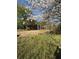 Expansive backyard with a shed and concrete walkway, framed by flowering trees and grass at 522 Stell Rd, Woodstock, GA 30188