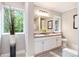 Bright bathroom with double sinks and a large window showing the view outside at 522 Stell Rd, Woodstock, GA 30188