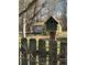 Charming green and red birdhouse on a post, nestled among trees and a rustic fence at 522 Stell Rd, Woodstock, GA 30188