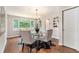 Elegant dining room with hardwood floors, a stylish chandelier, and view of the wooded lot at 522 Stell Rd, Woodstock, GA 30188
