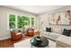 Bright living room with hardwood floors, comfortable seating, and a large window with a view of lush greenery at 522 Stell Rd, Woodstock, GA 30188