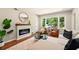 Inviting living room with a modern fireplace, comfortable seating, and a large window offering a peaceful outdoor view at 522 Stell Rd, Woodstock, GA 30188