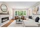 Inviting living room featuring a fireplace, hardwood floors, and large windows offering plenty of natural light at 522 Stell Rd, Woodstock, GA 30188