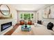 Cozy living room featuring a fireplace, hardwood floors, stylish furniture, and a bright window overlooking nature at 522 Stell Rd, Woodstock, GA 30188