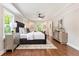 Bright main bedroom with a tray ceiling, ceiling fan, hardwood floors, and a decorative rug at 522 Stell Rd, Woodstock, GA 30188