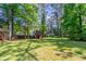 Expansive backyard with mature trees, a shed, and lush green grass perfect for outdoor activities at 142 Wellspring Pt, Hiram, GA 30141