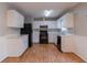 Bright kitchen boasts white cabinets, black appliances, and wood flooring at 142 Wellspring Pt, Hiram, GA 30141