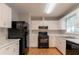 Well-lit kitchen featuring white cabinetry, black appliances, and ample counter space at 142 Wellspring Pt, Hiram, GA 30141