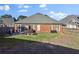 View of the backyard with a brick house, green grass, and a fence, perfect for outdoor activities at 1885 Hickory Station Cir, Snellville, GA 30078