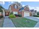 Charming two-story brick home featuring a well-manicured lawn and attached two-car garage at 1885 Hickory Station Cir, Snellville, GA 30078