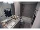 Modern bathroom featuring a granite vanity, a tile backsplash, and a shower-tub combo with gray tiling at 5663 Eternal Dr, Atlanta, GA 30349
