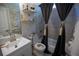 Cozy bathroom with white vanity, decorative shelves, tiled shower, and dark shower curtain at 5663 Eternal Dr, Atlanta, GA 30349