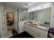 Bright bathroom featuring double sinks with granite counters, frameless glass shower, and a large vanity mirror at 5663 Eternal Dr, Atlanta, GA 30349