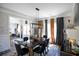 Formal dining room features a black dining table with gold accents, elegant lighting, and neutral decor at 5663 Eternal Dr, Atlanta, GA 30349