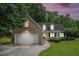 Charming brick home with two car garage and a well maintained front yard at dusk at 609 Ashton Manor Dr, Loganville, GA 30052