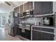 Modern kitchen with stainless steel appliances, dark cabinets and mosaic tile backsplash at 609 Ashton Manor Dr, Loganville, GA 30052