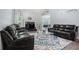 Cozy living room with hardwood floors, fireplace and comfortable leather sofas at 609 Ashton Manor Dr, Loganville, GA 30052