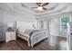 Bright main bedroom with hardwood floors, tray ceiling, and large windows allowing ample natural light at 609 Ashton Manor Dr, Loganville, GA 30052