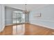 Dining room featuring shiny hardwood floors, chandelier, white trim, and a view of outside from the bright window at 1285 Rivershyre Pkwy, Lawrenceville, GA 30043
