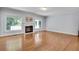 Open-concept living room featuring hardwood floors, white trim, fireplace, windows, and access to other rooms at 1285 Rivershyre Pkwy, Lawrenceville, GA 30043