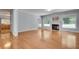Open-concept living room featuring fireplace, hardwood floors, white trim, access to other rooms, and bright windows at 1285 Rivershyre Pkwy, Lawrenceville, GA 30043