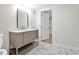 Modern bathroom featuring a sleek vanity with a black framed mirror and marble-patterned tile flooring at 4376 Riverwood Cir, Decatur, GA 30035