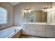 Bathroom with a large vanity, double sinks, granite countertop, and large soaking tub at 5492 Glenridge Dr # 536, Atlanta, GA 30342