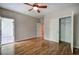 Bright bedroom featuring hardwood floors, a ceiling fan, and a door leading to an outdoor space at 5492 Glenridge Dr # 536, Atlanta, GA 30342