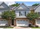 Charming townhome featuring a two-car garage, brick accents, lush landscaping, and impeccable curb appeal at 5492 Glenridge Dr # 536, Atlanta, GA 30342
