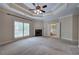 Large main bedroom with a fireplace, tray ceiling, and bathroom entrance at 5492 Glenridge Dr # 536, Atlanta, GA 30342