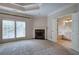 Expansive main bedroom featuring a fireplace, tray ceiling, and bathroom entrance at 5492 Glenridge Dr # 536, Atlanta, GA 30342
