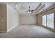 Large main bedroom with a tray ceiling, neutral carpet and walls, and shuttered windows at 5492 Glenridge Dr # 536, Atlanta, GA 30342