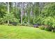 Expansive backyard surrounded by lush greenery, featuring play equipment and ample space for outdoor activities at 2041 Millspring Nw Way, Kennesaw, GA 30152