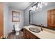 Cozy bathroom with decorative sink, framed mirror, and wood cabinets at 2041 Millspring Nw Way, Kennesaw, GA 30152
