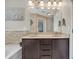 Bathroom with a double sink vanity, stone accent wall, and decorative lighting at 3982 Brockenhurst Dr, Buford, GA 30519