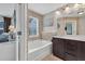Bathroom with a stone accent wall, double sink vanity, and adjacent soaking tub at 3982 Brockenhurst Dr, Buford, GA 30519