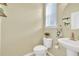 Powder room featuring a toilet and floating sink with a large round mirror at 3982 Brockenhurst Dr, Buford, GA 30519