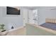 Well-lit bedroom with light wood floors, tv, and view to next room at 3982 Brockenhurst Dr, Buford, GA 30519