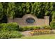 The Townes of Avondale entrance sign is surrounded by colorful flowers and lush landscaping at 3982 Brockenhurst Dr, Buford, GA 30519