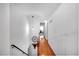 Hallway with hardwood floors, white walls and banister with decorative flower and hanging pendant light at 6863 Recreation Ln, Acworth, GA 30102