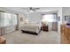 Spacious main bedroom with neutral carpeting, ceiling fan, and bright, light-filled windows at 6863 Recreation Ln, Acworth, GA 30102