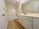 Well-lit bathroom featuring a vanity with cabinet storage, a large mirror, and a shower-tub combo at 2130 Chattahoochee Dr, Duluth, GA 30097