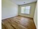 This bedroom features wood-look flooring, neutral walls, and a large window at 2130 Chattahoochee Dr, Duluth, GA 30097