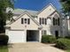 Exterior elevation with two-car garage; one door is open, and landscaped yard is visible at 2130 Chattahoochee Dr, Duluth, GA 30097