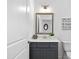 Updated bathroom with a gray vanity, white marble countertops, and decorative mirror at 302 Bunker Hill Ct, Acworth, GA 30102