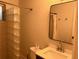 Bathroom featuring a tiled shower with glass block wall, sink with large mirror, and toilet at 375 6Th Ne St # 5, Atlanta, GA 30308