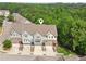 Aerial view showcasing a row of townhomes with individual garages and well-maintained surroundings at 4173 Chatham Ridge Dr, Buford, GA 30518