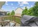 View of the home's deck with a Traeger grill and outdoor seating that overlooks a green, tree-filled backyard at 4173 Chatham Ridge Dr, Buford, GA 30518